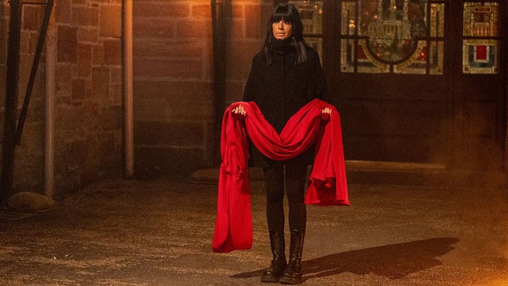 Claudia Winkleman holding the red cloak belonging to the secret traitor