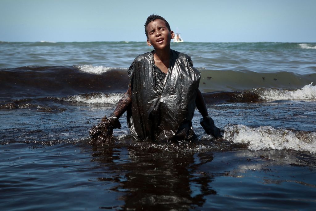Мальчик выходит из морского пляжа тапуама, расположенного в городе Кабо-де-Санто-Агостиньо, штат Пернамбуку, Бразилия