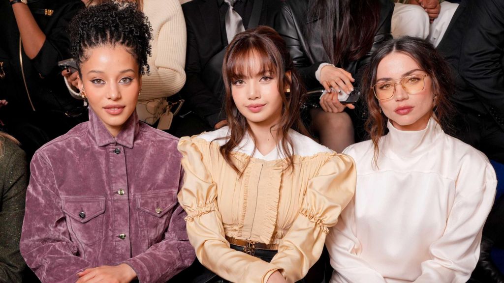 Chase Infiniti in a purple jacket, Lisa in a peach blouse, and Ana de Armas in a white high-necked top, at the Louis Vuitton fashion show