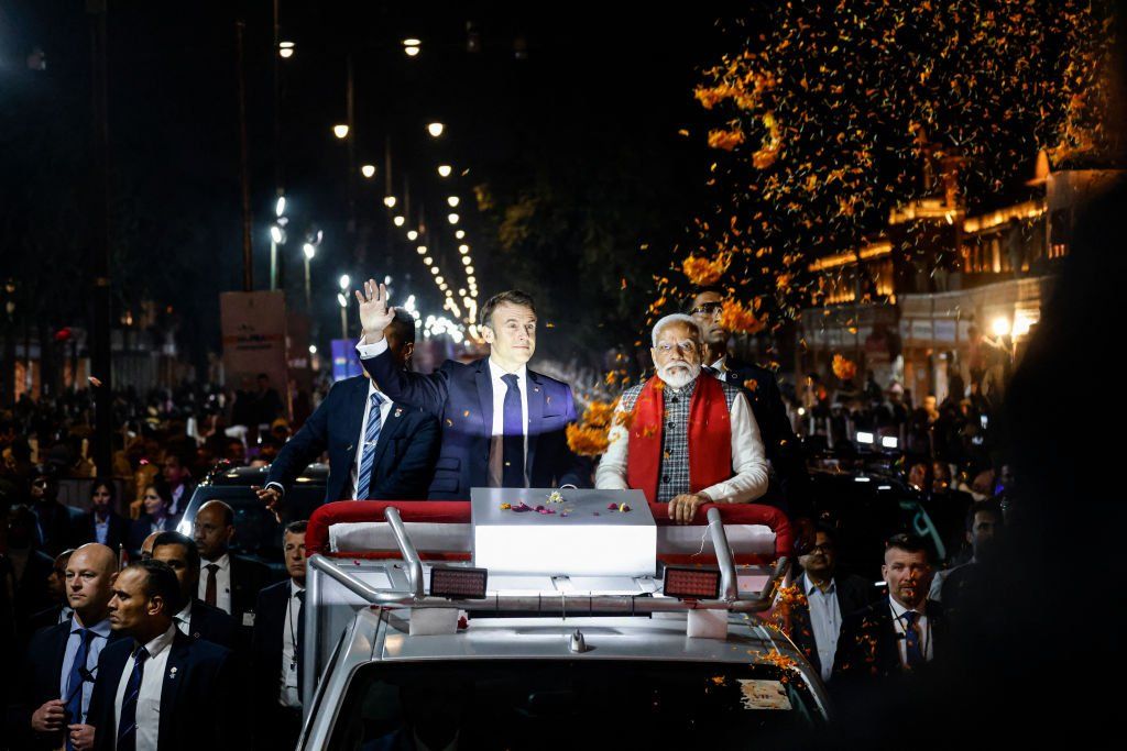 People shower flower petals over India's Prime Minister Narendra Modi and France's President Emmanuel Macron