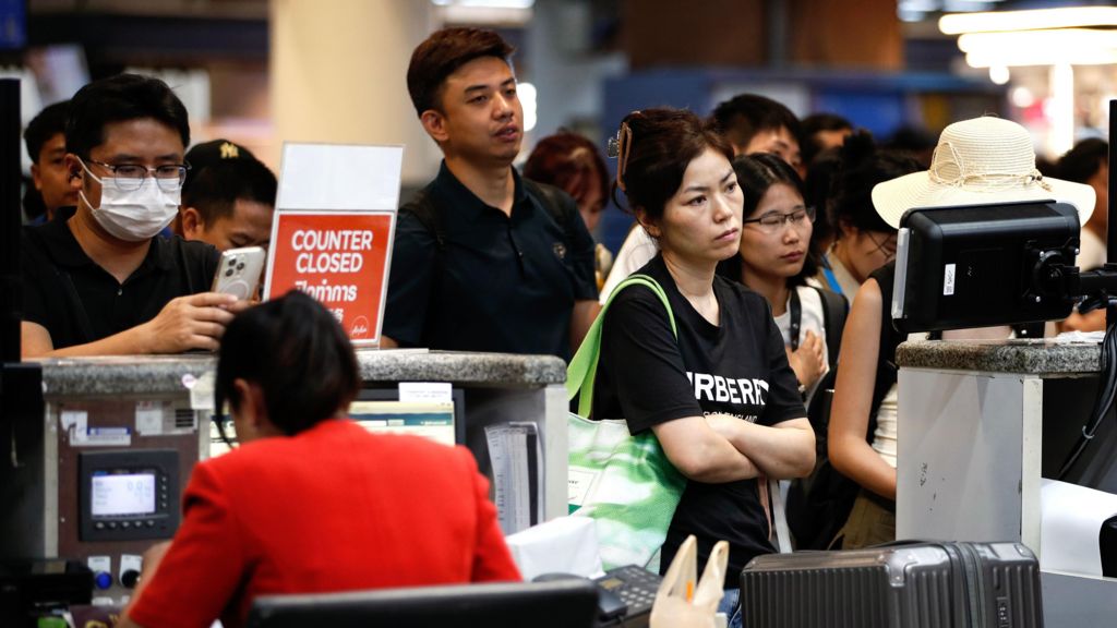 People standing at an airport during the IT problems caused by the CrowdStrike outage 