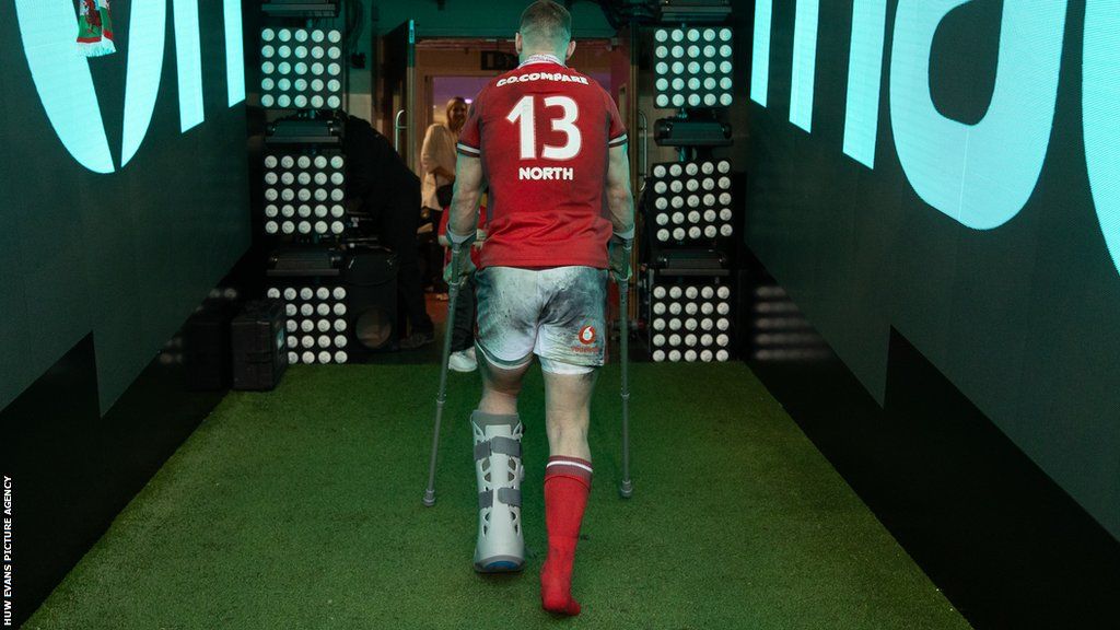 George North leaves the Principality Stadium pitch for the final time on crutches after being injured in the 24-21 defeat against Italy