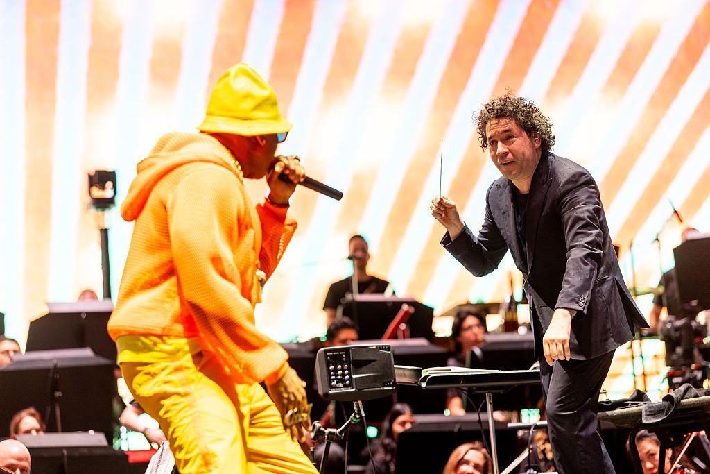 LL Cool J watches conductor Gustavo Dudamel as they perform with the LA Philharmonic at the Coachella Festival