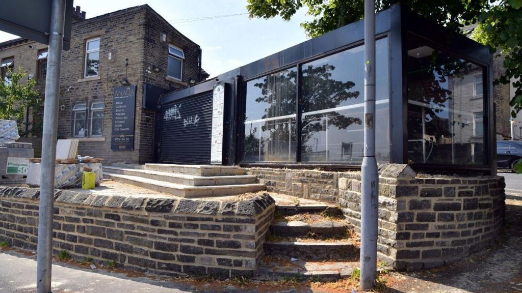 The site in Horton Park Avenue shows a closed gift shop to the left with an extension stretching across the mid-height stone terrace