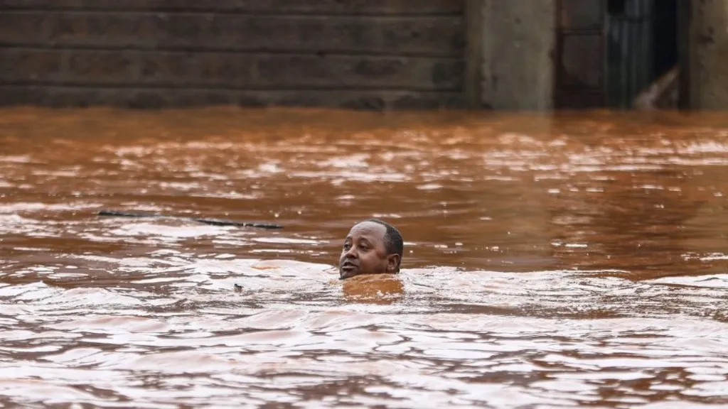 A man in Nairobi is submerged in water as he swims to rescue stranded residents who were trapped in their homes