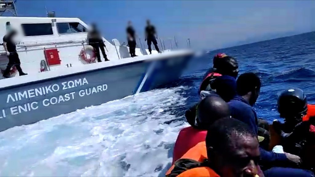 A migrant boat next to a Greek Coastguard boat