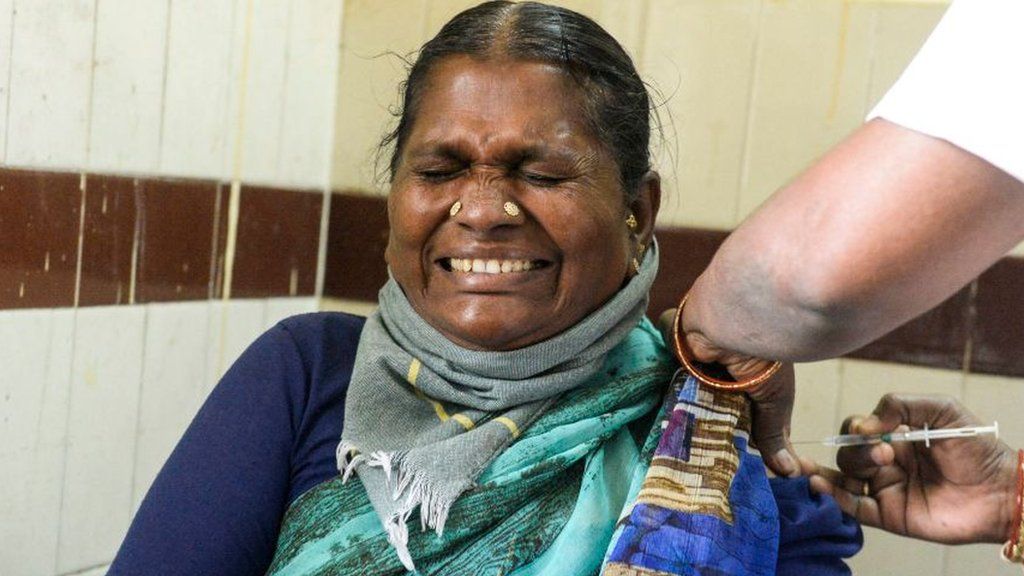 A woman reacts as a medical staff inoculates her with a Covid-19 coronavirus vaccine at a government hospital in Siddipet, in the Indian state of Telangana on March 1, 2021, as the country begins a vaccination programme for senior people.