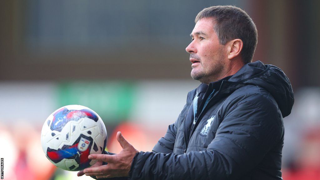 Mansfield boss Nigel Clough catches a ball pitch side