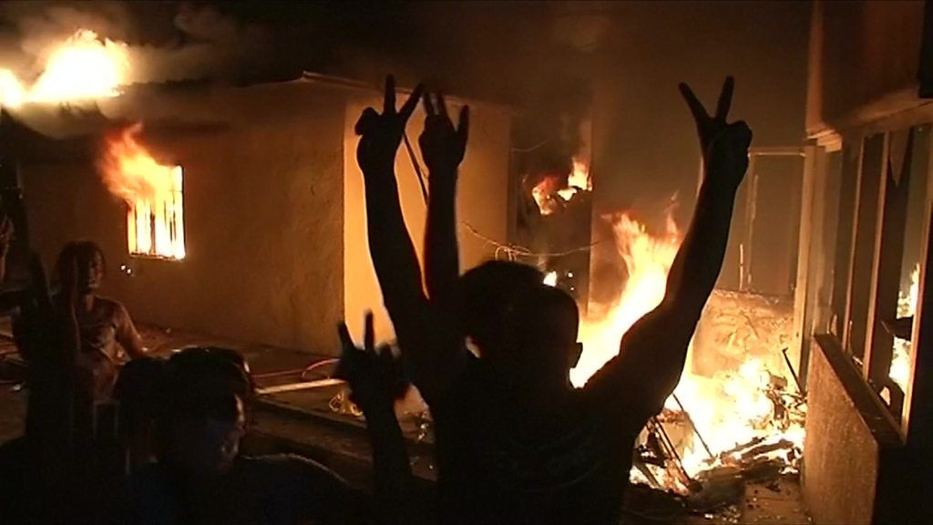 Protesters torched several buildings and made victory signs