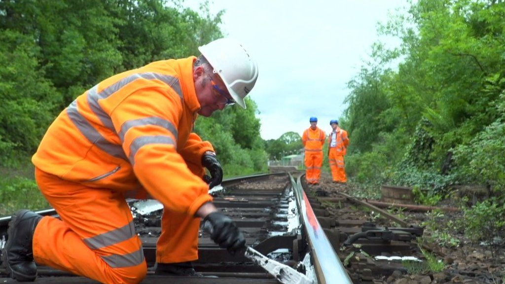 Rail worker painting the rails white