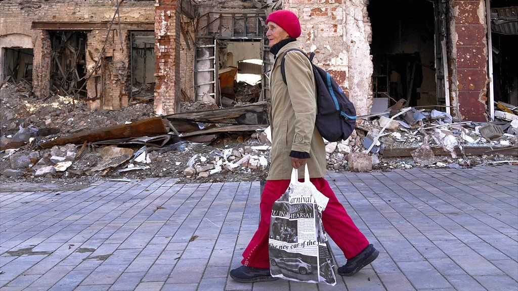 A woman walks past the damaged area after clashes are occurred as Russia-Ukraine war continues in Mariupol, Donetsk Oblast, Ukraine on September 29, 2022.