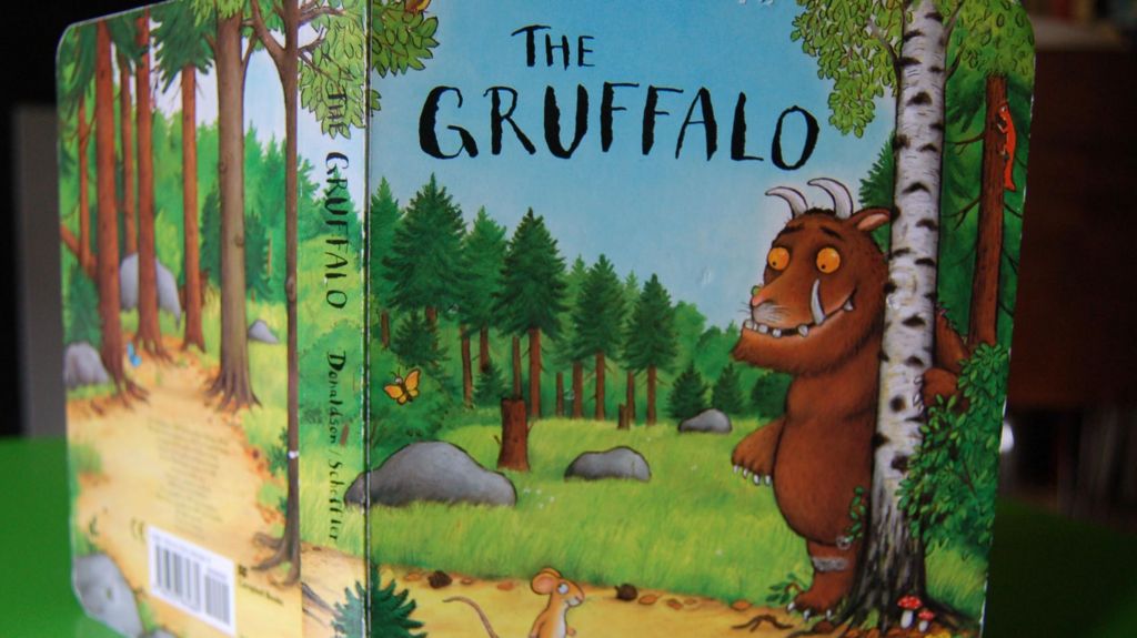 A picture of the orginal Gruffalo book cover, open and stood up on a green table