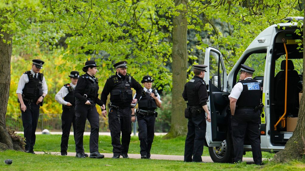 Several police officers getting out of a van in Kensington Gardens