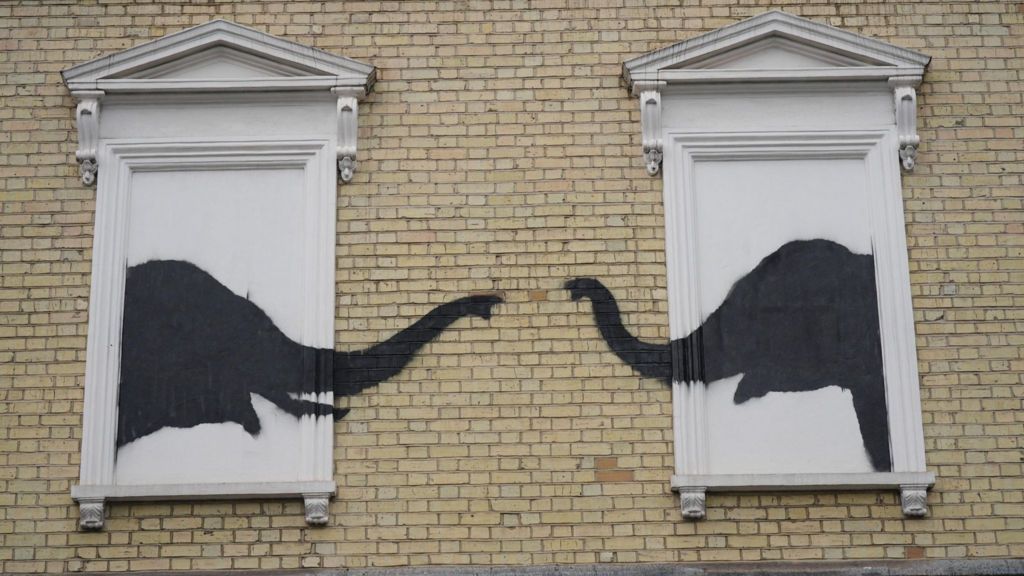 The photo of the two elephants stencilled onto the side of a building