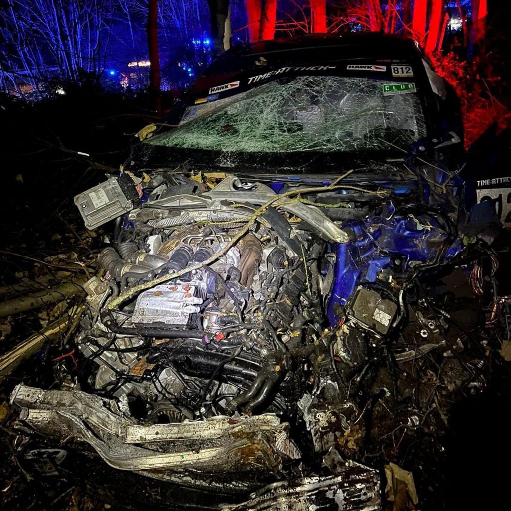 Badly-damaged car in woodland