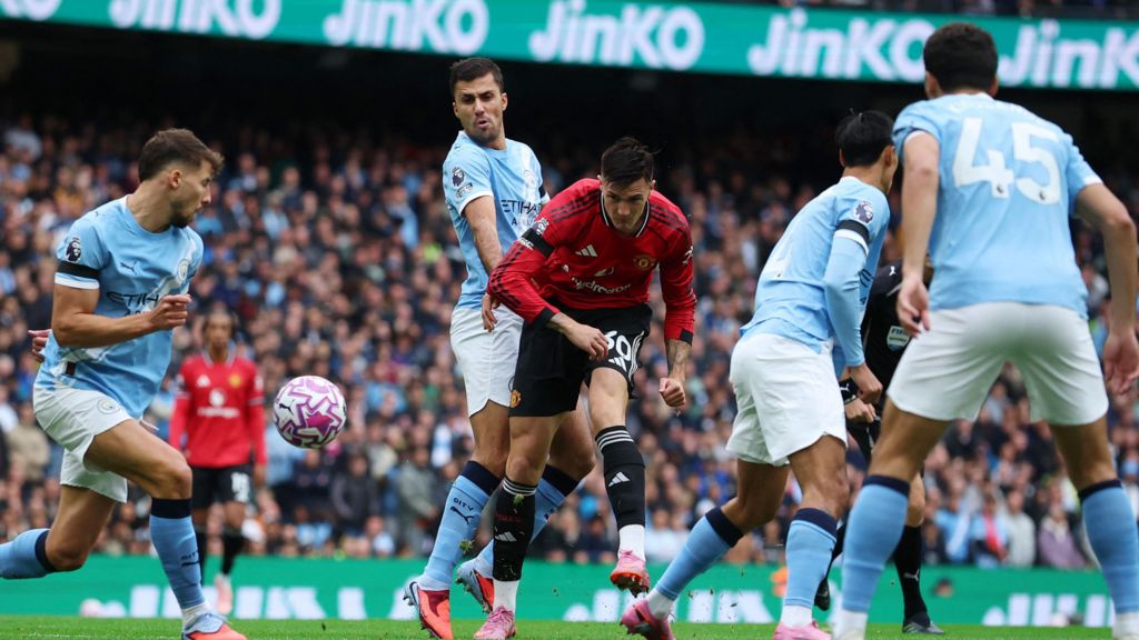 Manchester City's Ruben Dias in action with Manchester United's Benjamin Sesko with several other Manchester City players in view