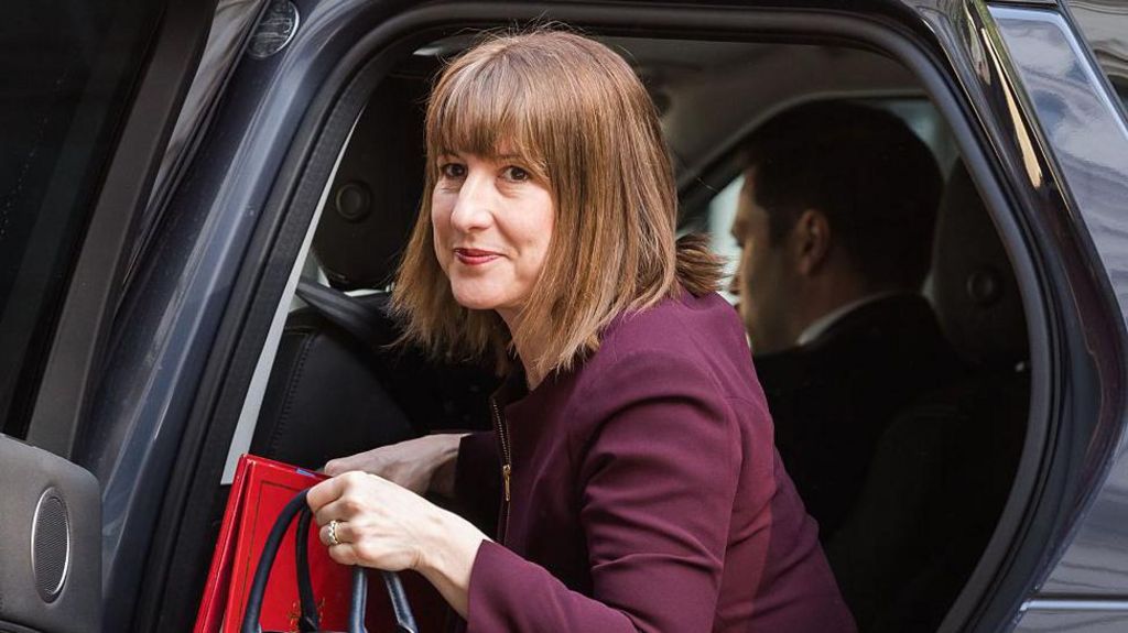 Chancellor Rachel Reeves getting out of a cab outside Downing Street in May, wearing a maroon suit and carrying a handbag and red folder