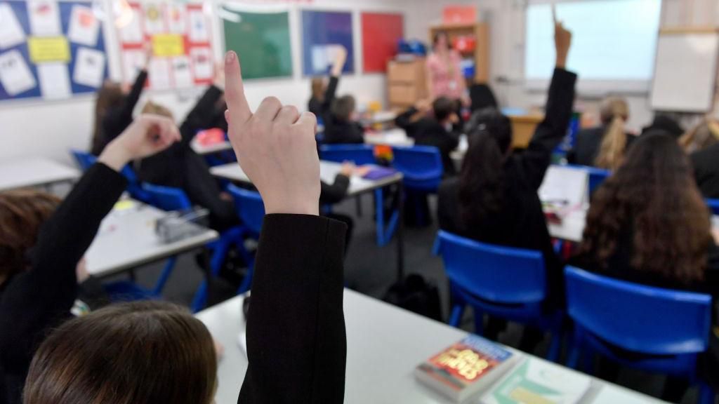 Children raising their hands in a classroom