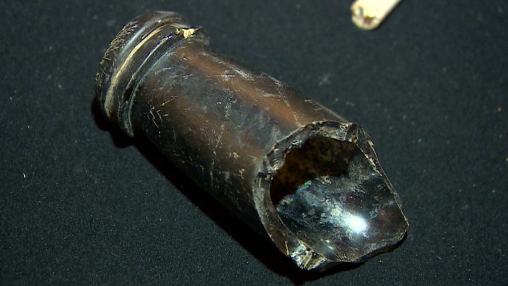 The bottle end of a broken wine bottle, in black