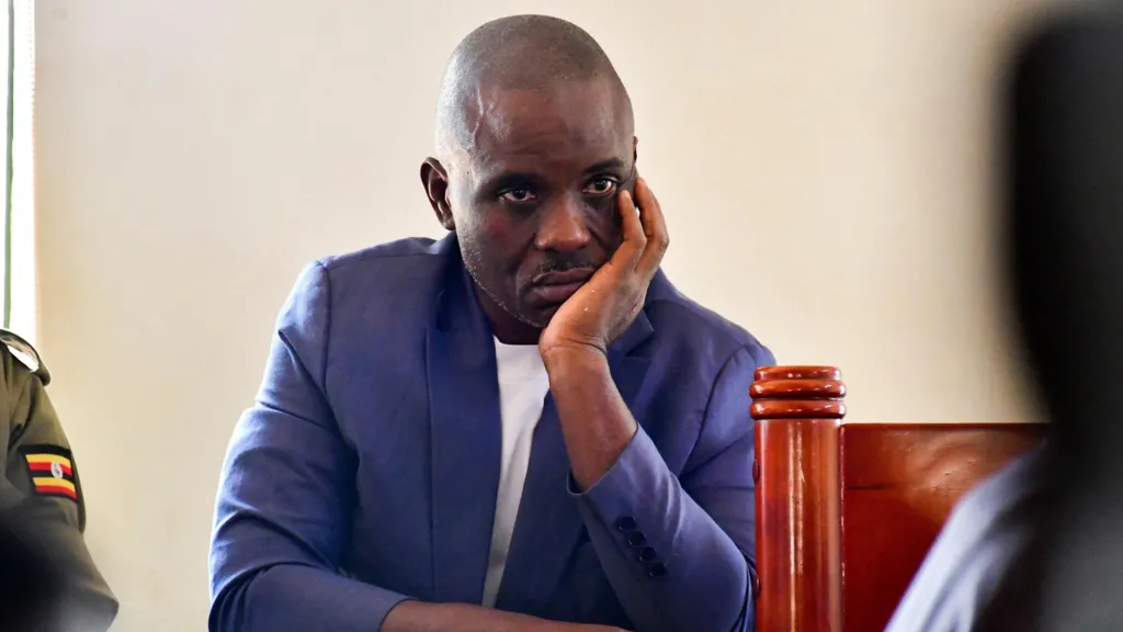 Erias Lukwago, in a navy blue jacket and white shirt appears in the dock