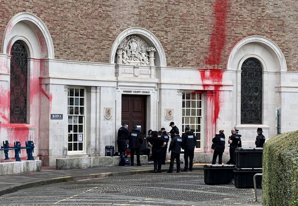 Police officers outside Somerset County Hall, which is covered in red paint