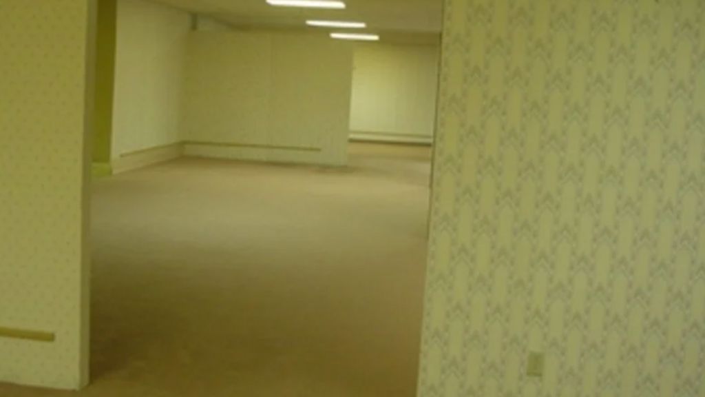 The original image uploaded for the Backrooms, showing abandoned segmented walls and rooms, with mustard yellow wallpaper