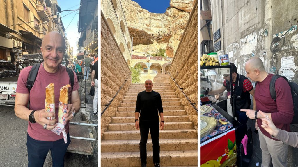 Three photos side-by-side across the screen, showing Imad Alarnab during his visit to Syria. On the left, he is shown standing in a busy street with traffic behind him, holding two wraps and looking at the camera, smiling. In the middle, he is standing at the bottom of a set of stone steps at a historical site. On the right, he is standing in front of a kiosk at a street food stall, talking to a man who is preparing some food.
