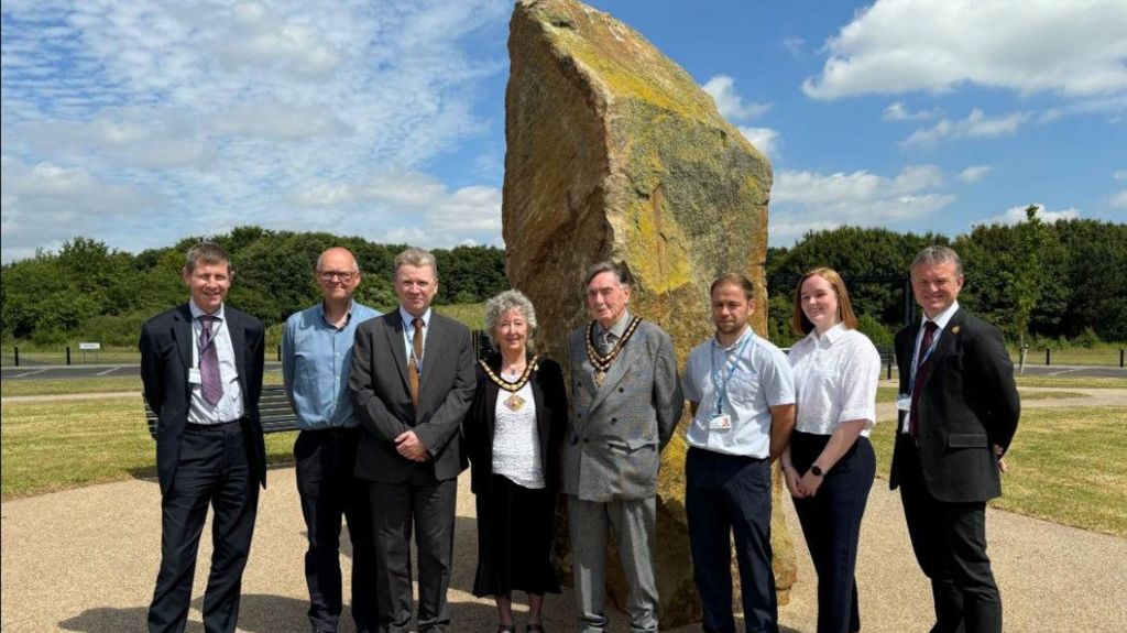 Councillors and officials standing by the new cemetery's Pennine stone monolith