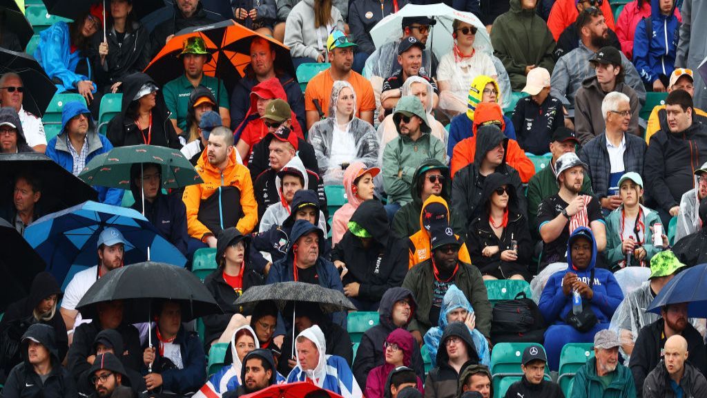 Fans watch the action at Silverstone with umbrellas and hoods up 