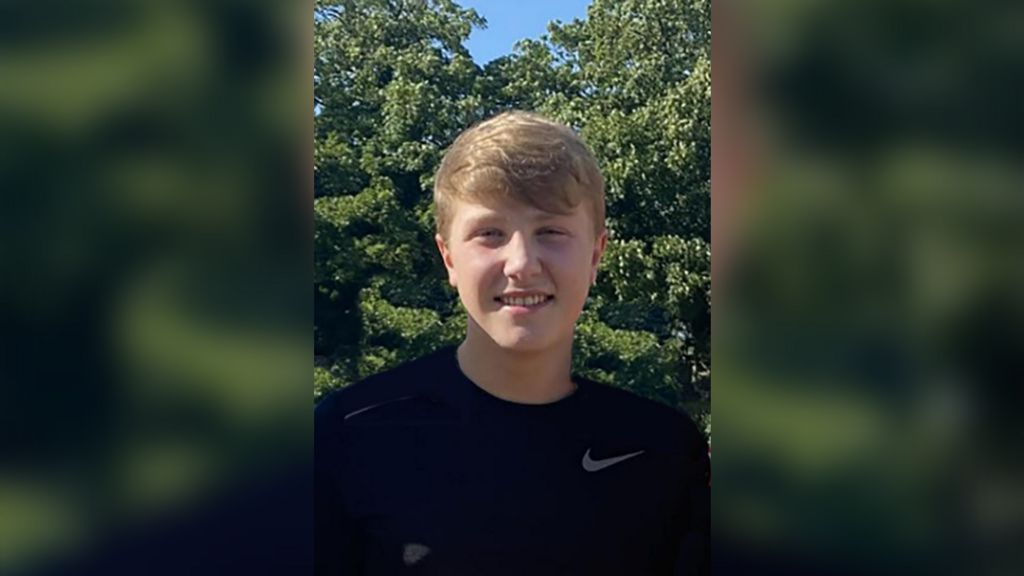 Matthew Daulby smiling at the camera, wearing a black Nike t-shirt, he has blonde short hair and light eyes. 