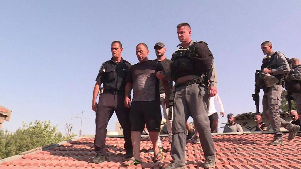 Police escort Palestinian man off roof
