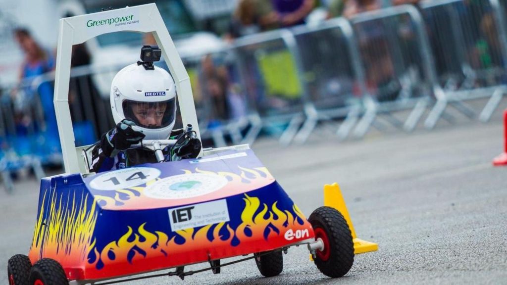A child races an electric kit car