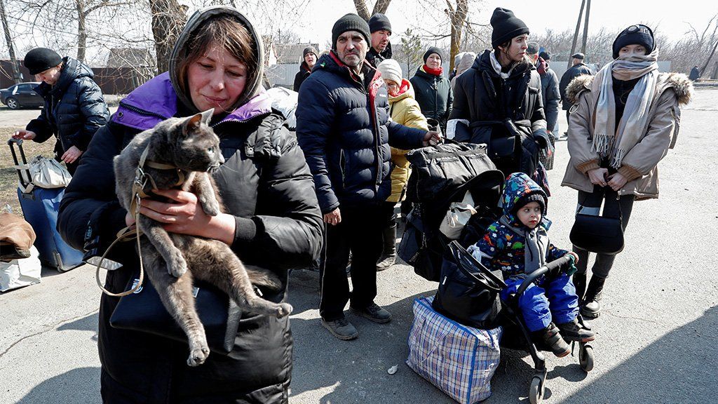 Evacuees wait for a bus before leaving Mariupol, 24 March 2022