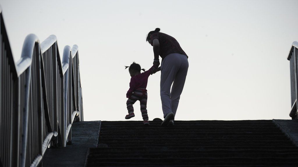 A family makes their way along the steps of a footbridge in Beijing