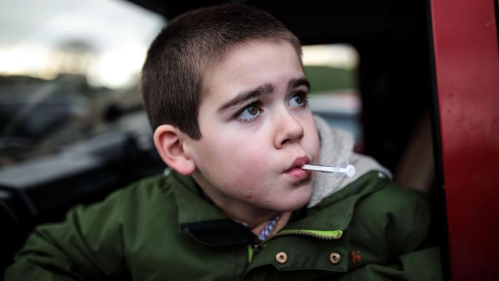 Alfie Dingley takes his cannabis oil medicine as he sits in a car at Kenilworth Castle in 2019 in Kenilworth, England