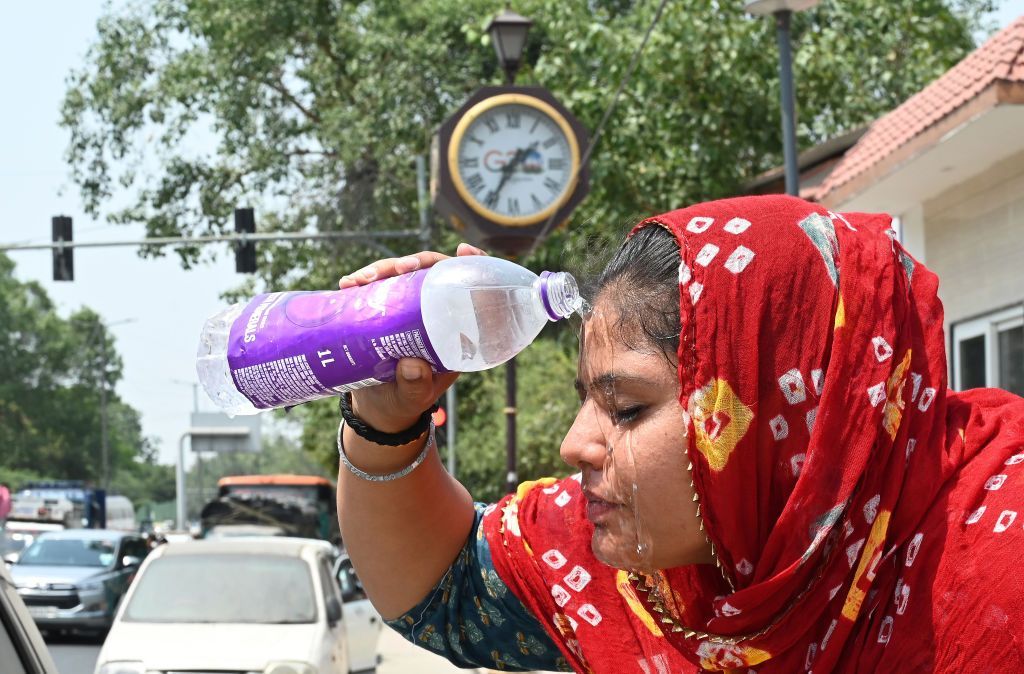 A young girl washes her face as increasing temperature during hot weather, on May 18, 2024 in New Delhi, India.