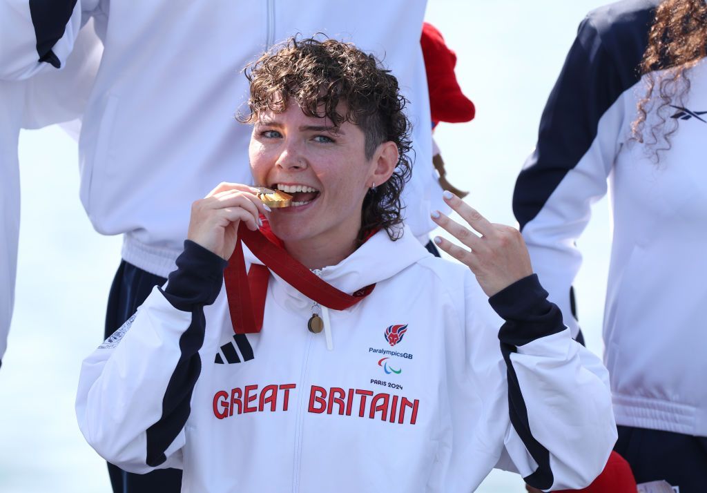 Lauren Rowles holding the Paralympic gold medal for winning the PR2 mixed double sculls