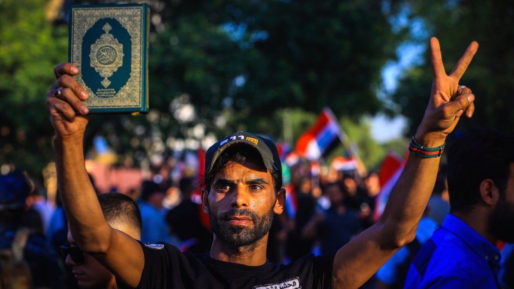 Protester holding up Quran during Baghdad protest against Denmark Quran-burning