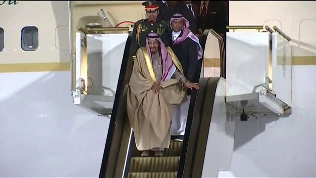 King Salman disembarks plane via gold escalator