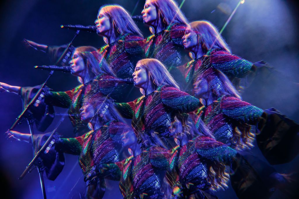 A kaleidoscopic photograph of Freya Ridings in concert, with the singer's image refracted in a sea of blue and purple lights