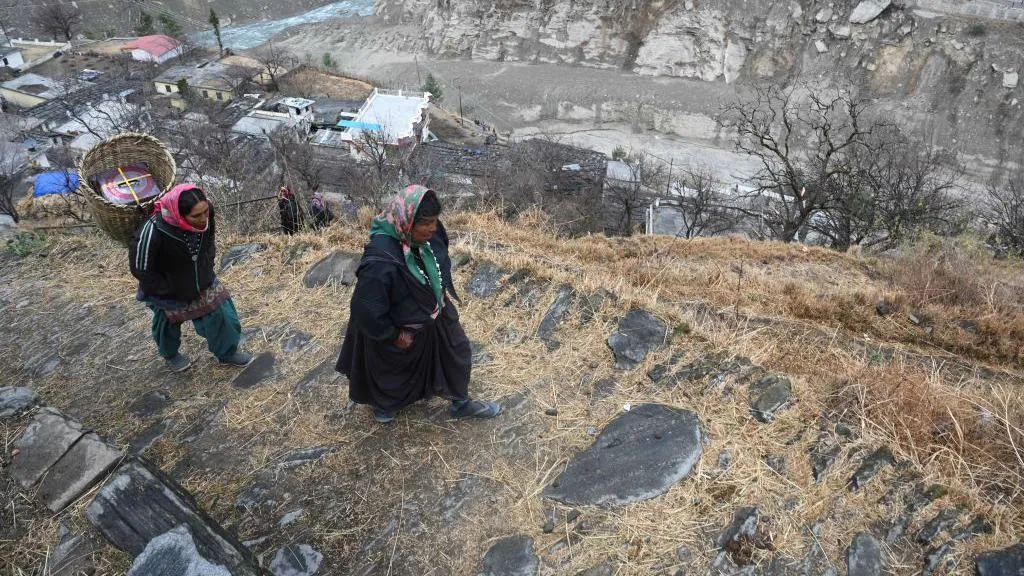 In this picture taken on February 10, 2021, women from Raini Chak Lata village walk along a mountain path in Chamoli district. - Long before this month's deadly flash flood in a remote Indian Himalayan valley, Kundan Singh Rana knew that all the construction work in the fragile region would one day mean disaster.