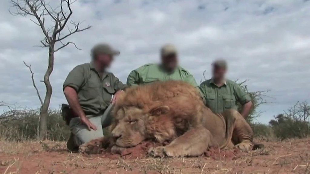 Hunters with a dead lion