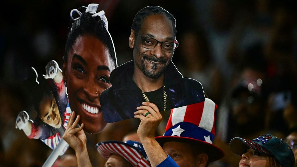 Fans in the Olympics stands hold a poster image of Snoop Dogg