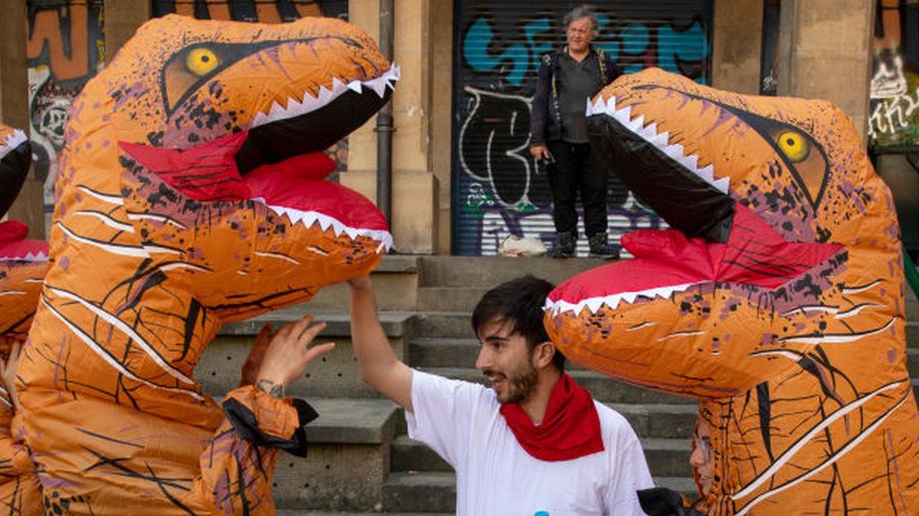 Protesters against Pamplona's bull-running festival wearing dinosaur outfits
