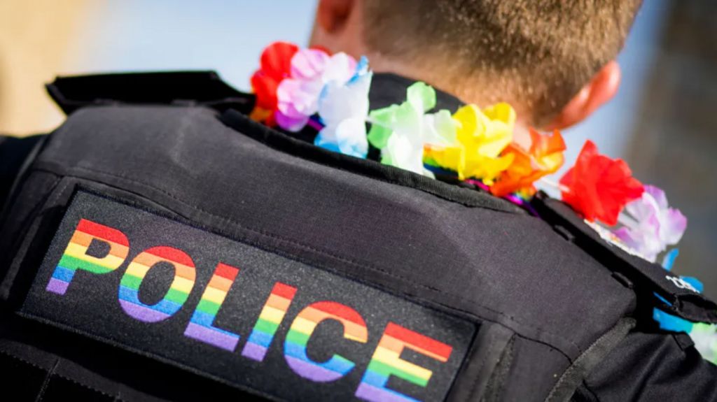 A police officer with a rainbow logo