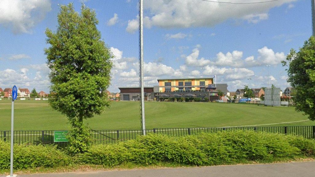 View across Boundary Park with cricket nets in the foreground and a large pavilion building on the opposite side