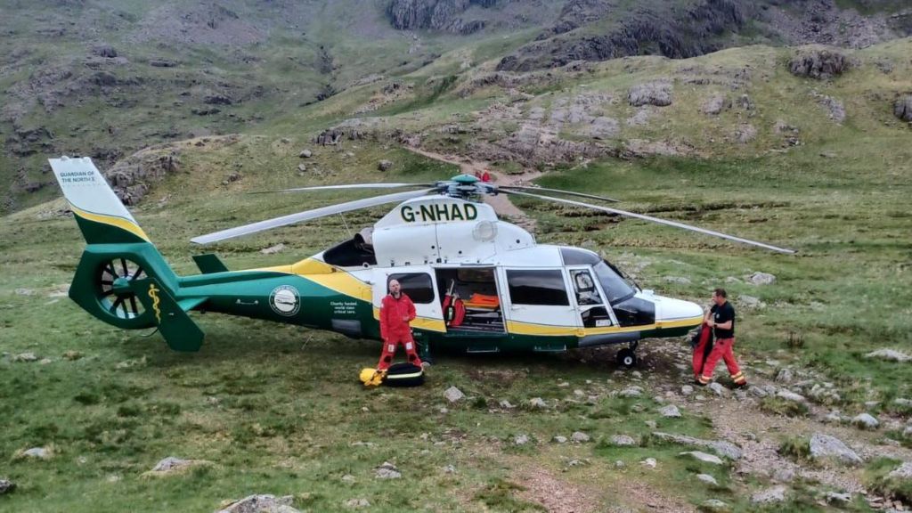 An air ambulance with green and yellow markings is seen at the site of the incident. 