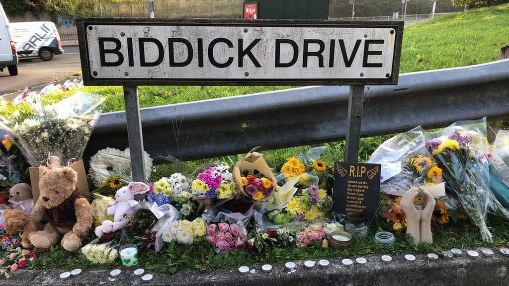 Flowers lay next to Biddick Drive sign