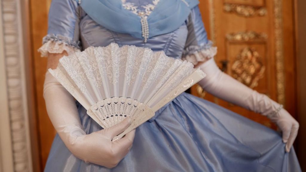 Close up of lady wearing blue ballgown curtsying