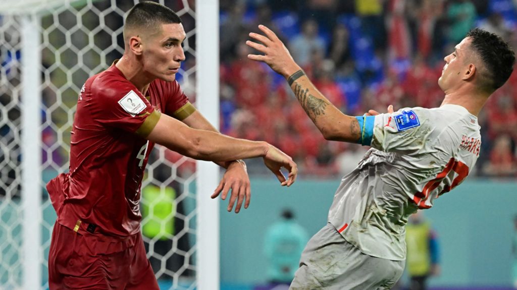 Serbia's Nikola Milenkovic pushes Switzerland's midfielder Switzerland's Granit Xhaka during a match at the 2022 World Cup in Qatar